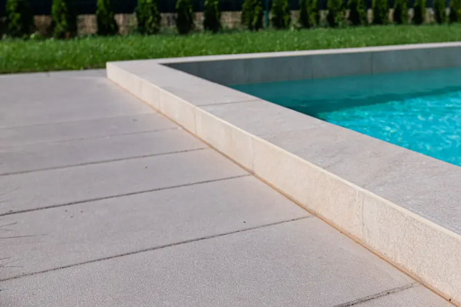 Verlegte Terrassenplatten mit schmalen Fugen am Rand eines Pools
